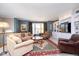 Comfortable living room featuring a large sofa, armchairs, and a built-in entertainment center with shelving at 651 Greenford N Trl, Carmel, IN 46032