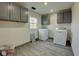 Clean laundry room featuring gray cabinets, modern washer, dryer, and wood-look floors at 6780 N Michigan Rd, Fairland, IN 46126