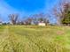 Wide expanse of grassy area showing mature trees and outbuildings in an open space at 6780 N Michigan Rd, Fairland, IN 46126