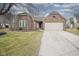 Charming brick home featuring an attached two-car garage and well-maintained lawn at 7031 Sea Eagle Ct, Indianapolis, IN 46254