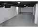 Unfinished basement area featuring painted concrete floor, white walls, and black ceiling at 7144 Sandalwood Dr, Indianapolis, IN 46217