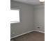 Cozy bedroom featuring plush carpeting, neutral walls, window with natural light, and white trim at 7144 Sandalwood Dr, Indianapolis, IN 46217