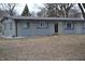 Exterior home view featuring gray siding, black roof, and yard with some shrubs and trees at 7144 Sandalwood Dr, Indianapolis, IN 46217