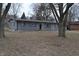 Front exterior view of house featuring gray siding, black roof, and a small front yard at 7144 Sandalwood Dr, Indianapolis, IN 46217