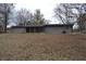 Back exterior view of house featuring gray siding and an open backyard at 7144 Sandalwood Dr, Indianapolis, IN 46217