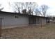 Back exterior view of house featuring gray siding and a small back porch at 7144 Sandalwood Dr, Indianapolis, IN 46217