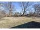 Large backyard featuring mature trees and a firepit at 8230 E 12Th St, Indianapolis, IN 46219