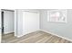 A light gray bedroom featuring vinyl flooring, a closet, and a bright window at 8230 E 12Th St, Indianapolis, IN 46219