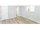 Bright bedroom featuring light gray walls, a window for natural light, and modern vinyl plank flooring at 8230 E 12Th St, Indianapolis, IN 46219