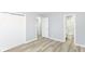 Bedroom with closet and connecting bathroom, featuring light gray walls and wood-look vinyl flooring at 8230 E 12Th St, Indianapolis, IN 46219