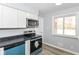 Modern kitchen featuring updated appliances, white cabinets, and neutral countertops at 8230 E 12Th St, Indianapolis, IN 46219