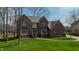 Charming brick two-story home featuring lush green lawn and mature trees at 895 Baywood Ct, Columbus, IN 47201