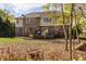 Exterior view of a two-story home with a lush backyard, wooden deck, and brick and green siding at 9643 N Box Elder Ct, McCordsville, IN 46055
