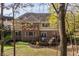 Back of the house with large windows, a wooden deck, and a sloped backyard with mature trees at 9643 N Box Elder Ct, McCordsville, IN 46055