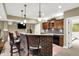 Basement bar area with brick accents, pendant lighting, wood cabinets, and access to other rooms at 9643 N Box Elder Ct, McCordsville, IN 46055
