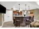 Basement bar area with brick accents, wood cabinets, pendant lighting and bar stool seating at 9643 N Box Elder Ct, McCordsville, IN 46055