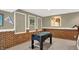 Foosball table in the basement game room surrounded by brick accents and wall decorations at 9643 N Box Elder Ct, McCordsville, IN 46055