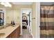 Bathroom with double sinks, doorway to a bedroom, and a view of bedroom furniture at 9643 N Box Elder Ct, McCordsville, IN 46055