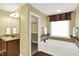 Bright bathroom featuring tub, granite countertops, and view into walk-in closet at 9643 N Box Elder Ct, McCordsville, IN 46055