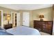 Neutral bedroom featuring a bed, dressers, and doors to an ensuite bath and closet at 9643 N Box Elder Ct, McCordsville, IN 46055