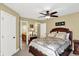 Bedroom featuring a wooden bed frame with decorative quilt, fan lighting, and ensuite bathroom access at 9643 N Box Elder Ct, McCordsville, IN 46055