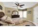 Comfortable bedroom with a large bed, wood furniture, a ceiling fan, and natural light from a bright window at 9643 N Box Elder Ct, McCordsville, IN 46055
