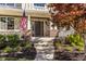 Charming front porch with stone and brick accents, an American flag, and lush landscaping at 9643 N Box Elder Ct, McCordsville, IN 46055