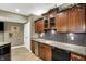 Kitchen with wooden cabinets, stainless steel appliances, tiled backsplash, and access to other rooms at 9643 N Box Elder Ct, McCordsville, IN 46055
