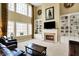 Inviting living room featuring a fireplace, built-ins, large windows, and comfortable seating at 9643 N Box Elder Ct, McCordsville, IN 46055