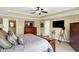 Main bedroom with ceiling fan, dresser, and view of the ensuite bathroom at 9643 N Box Elder Ct, McCordsville, IN 46055