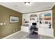 Well-lit home office featuring custom built-in shelving, desk space, and neutral decor at 9643 N Box Elder Ct, McCordsville, IN 46055
