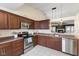 Well-equipped kitchen with stainless steel appliances, wood cabinets, and backyard views at 10441 Alexia Dr, Indianapolis, IN 46236