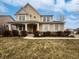 Charming two-story home featuring a covered porch, landscaped yard, and a mix of stone and stucco facade at 11134 Westoves Dr, Noblesville, IN 46060