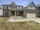 Traditional two-story brick home featuring red shutters, attached two car garage and manicured front lawn at 12036 Weathered Edge Dr, Fishers, IN 46037
