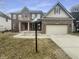 Traditional two-story brick home featuring red shutters, attached two car garage and landscaped front yard at 12036 Weathered Edge Dr, Fishers, IN 46037