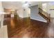 Open-concept living room, hardwood floors, stairs, and a glimpse into the kitchen area at 12036 Weathered Edge Dr, Fishers, IN 46037