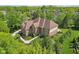 Stunning aerial view of a brick home with a well-manicured lawn, landscaping, and a driveway nestled among mature trees at 13133 Brooks Landing Pl, Carmel, IN 46033