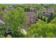 An aerial view showcases a home among lush trees, revealing its brick exterior, expansive driveway, and well-maintained lawn at 13133 Brooks Landing Pl, Carmel, IN 46033
