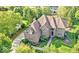 Stunning aerial view of a brick home surrounded by lush landscaping and mature trees at 13133 Brooks Landing Pl, Carmel, IN 46033