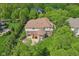 Aerial shot displays a home's backyard, patio, and landscape nestled within surrounding trees and neighboring residences at 13133 Brooks Landing Pl, Carmel, IN 46033