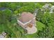Aerial image features a home with brick accents, manicured lawn, patio, and driveway, encircled by mature trees and green space at 13133 Brooks Landing Pl, Carmel, IN 46033