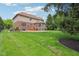 Expansive backyard with well-kept lawn, stone patio, wooden deck, and a view of the home's brick and siding exterior at 13133 Brooks Landing Pl, Carmel, IN 46033