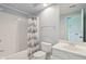 Bright bathroom featuring a white vanity, toilet, and bathtub with a blue-and-white nautical-themed shower curtain at 13133 Brooks Landing Pl, Carmel, IN 46033