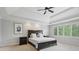 Spacious bedroom features a tray ceiling, fan, neutral paint and large windows with shutters at 13133 Brooks Landing Pl, Carmel, IN 46033