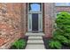 Close-up of front door with decorative sidelights and manicured landscaping at 13133 Brooks Landing Pl, Carmel, IN 46033