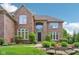 Attractive brick home with an arched entryway, complemented by lush greenery and a well-kept lawn at 13133 Brooks Landing Pl, Carmel, IN 46033
