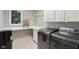 Well-lit laundry room with modern washer and dryer, ample counter space, and white cabinetry at 13133 Brooks Landing Pl, Carmel, IN 46033