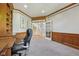 Home office featuring paneled walls, wooden built-in bookshelves, carpet flooring, and stairs nearby at 13133 Brooks Landing Pl, Carmel, IN 46033