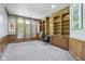Home office with wooden built-in bookshelves, paneled walls, and large windows offering plenty of natural light at 13133 Brooks Landing Pl, Carmel, IN 46033