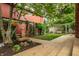 Backyard featuring a concrete patio and walkway, fountain, and lush garden with mature trees at 1320 N New Jersey St, Indianapolis, IN 46202